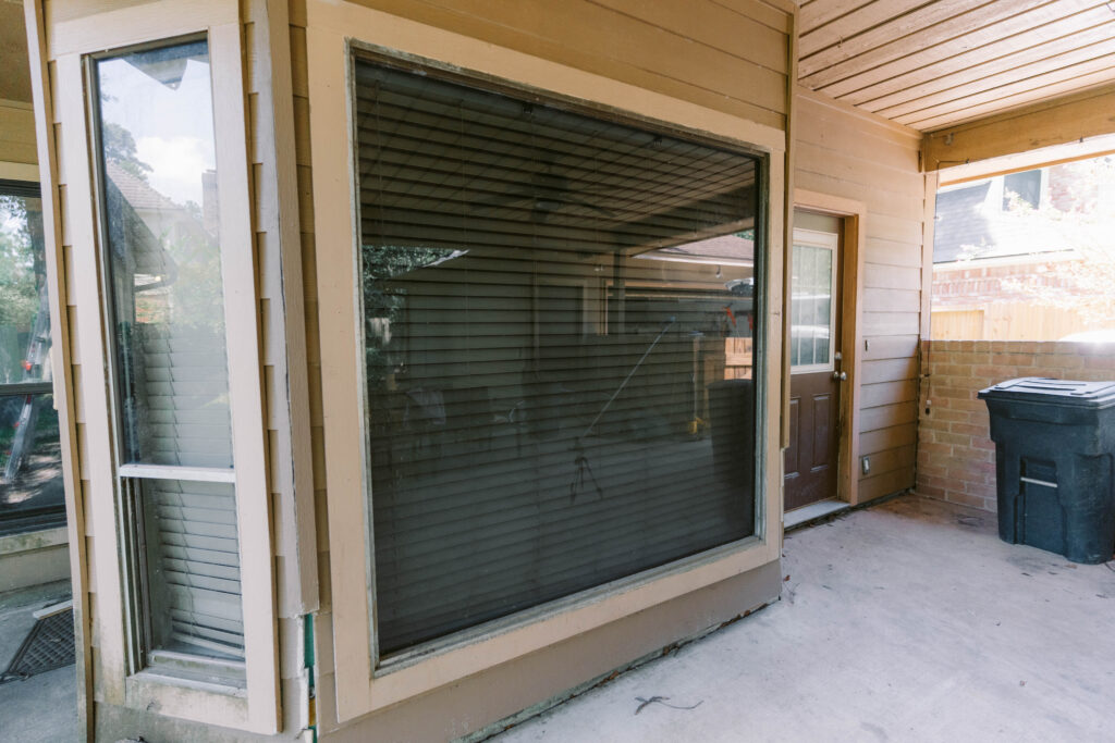 Residential patio window showing dirt and grime before window cleaning in Houston, TX.