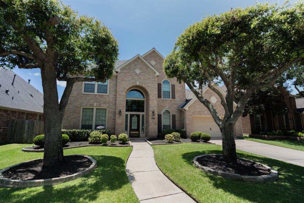 Residential home with clean landscaping before exterior window cleaning service in Houston, TX.
